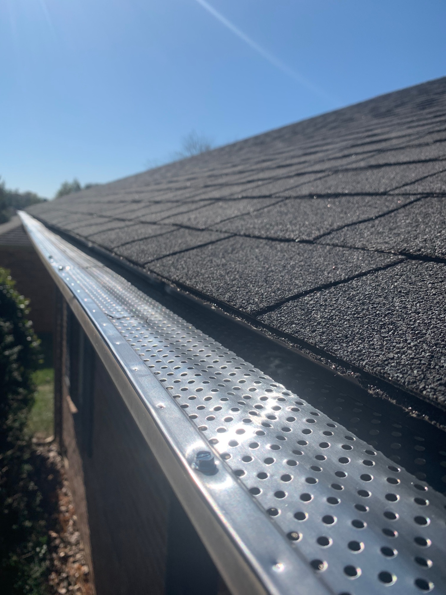 Roof of a house showing gutter and gutter guard protection against leaves Home maintenance